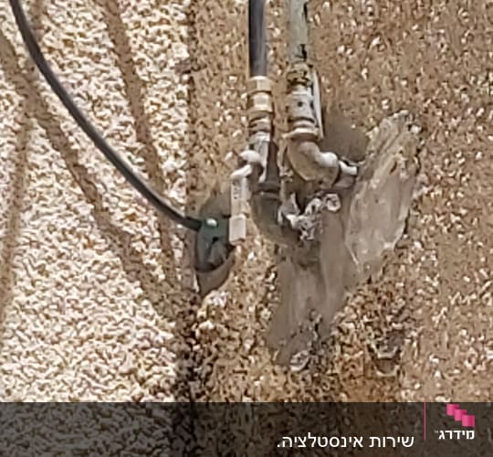 צינורות מחוברים לקיר עם מחברים מתכתיים